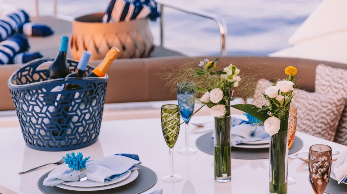 a table with plates and glasses aboard MELI Yacht for Charter