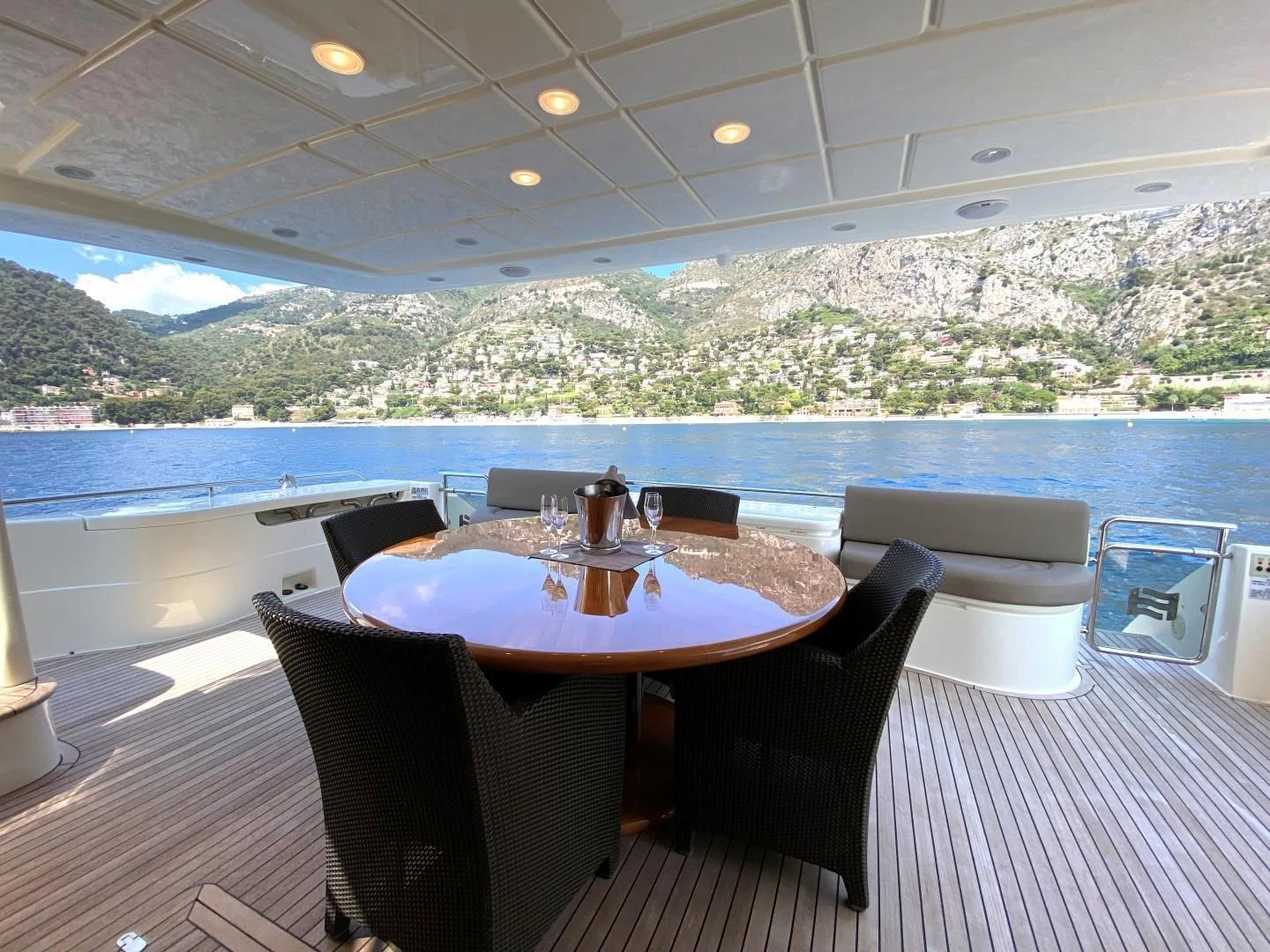 a table and chairs on a deck overlooking a body of water aboard MELI Yacht for Charter