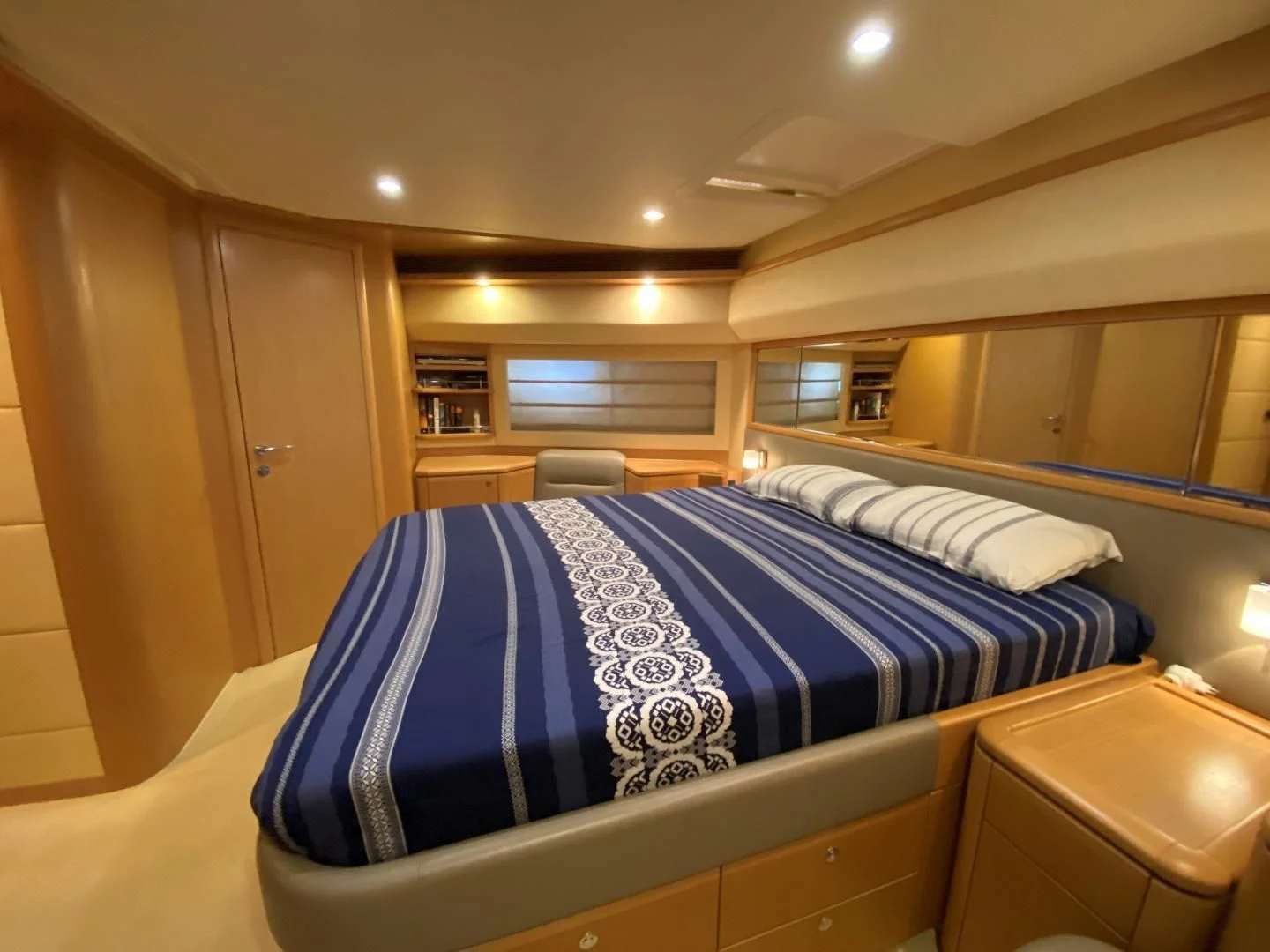 a bed with a blue and white striped blanket aboard MELI Yacht for Charter