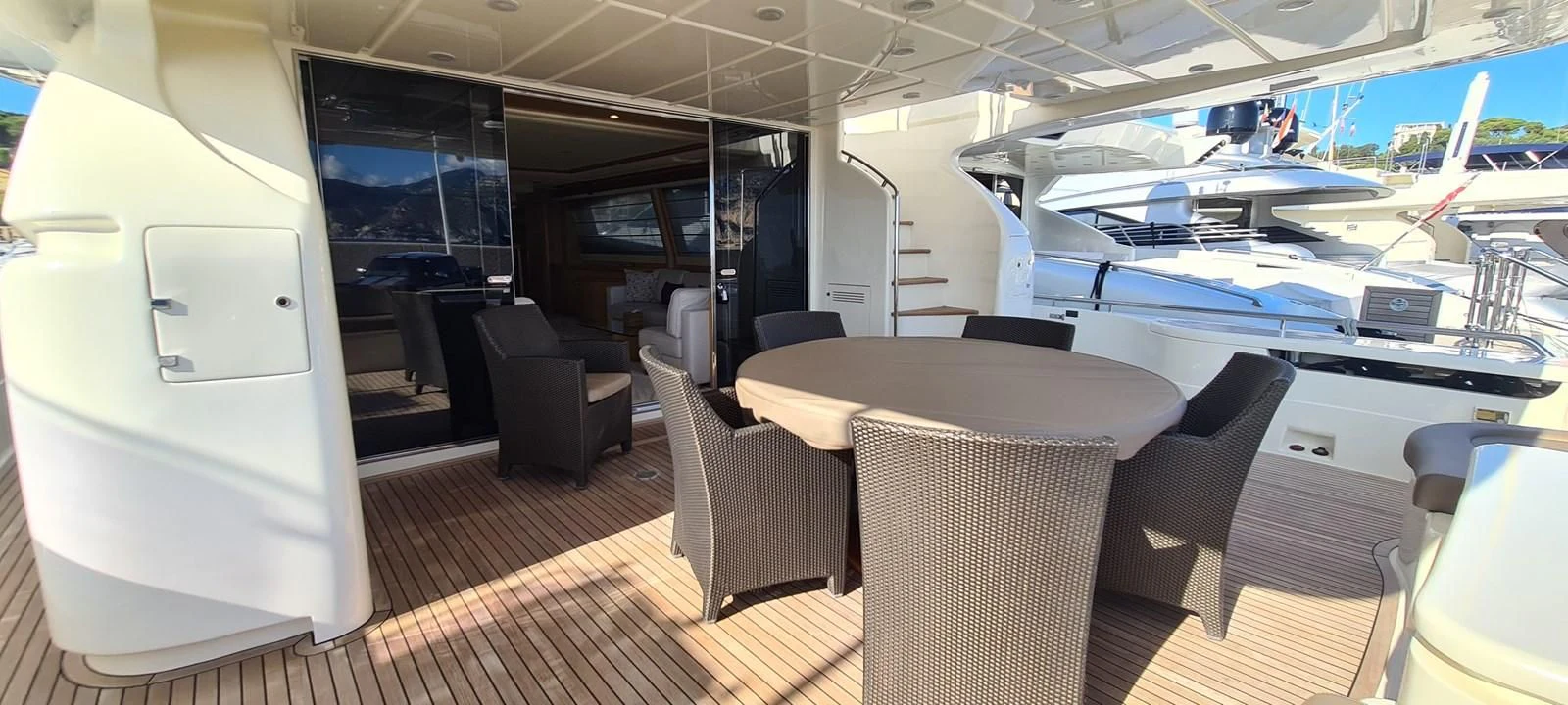 a room with a table chairs and a plane in the background aboard MELI Yacht for Charter