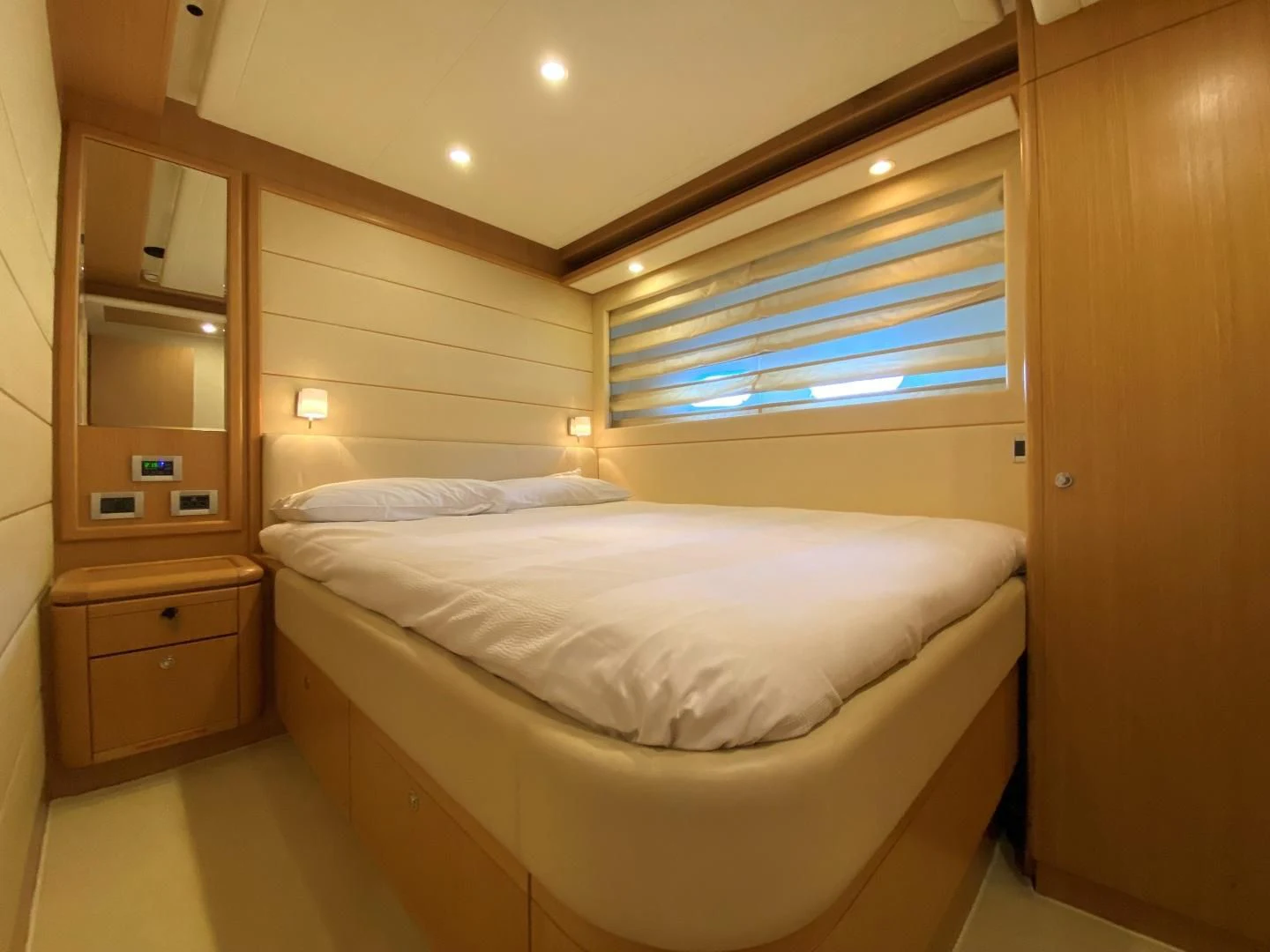 a room with a bed and a shelf with a mirror aboard MELI Yacht for Charter