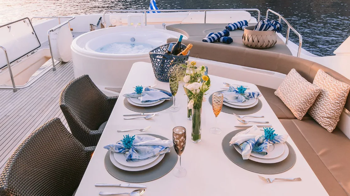 a table with plates and flowers on it aboard MELI Yacht for Charter