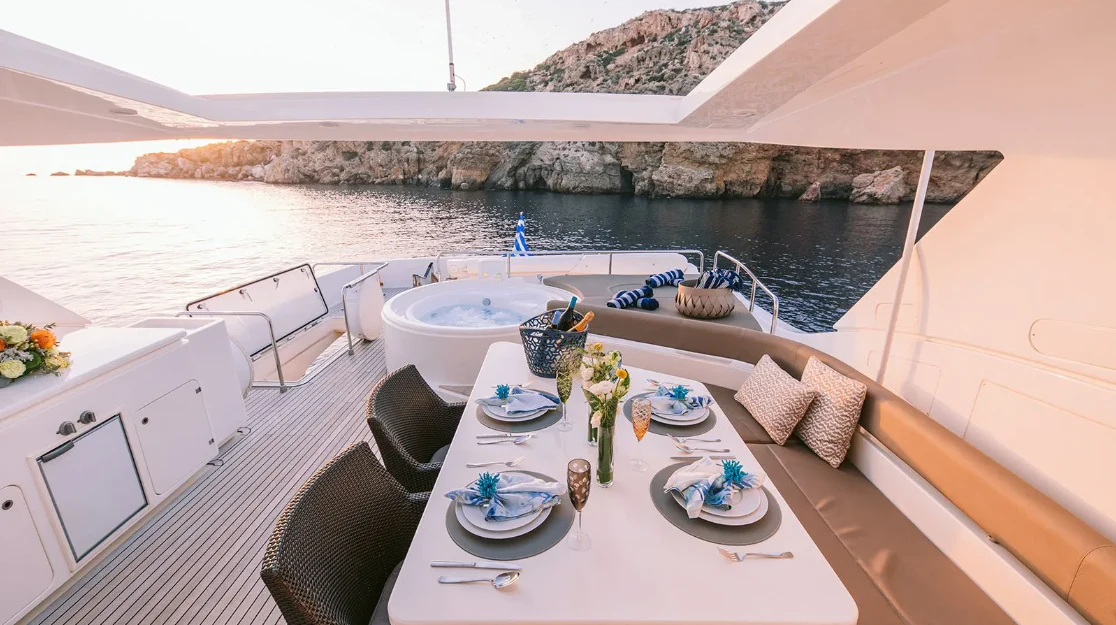 a table with plates and food on it on a balcony aboard MELI Yacht for Charter