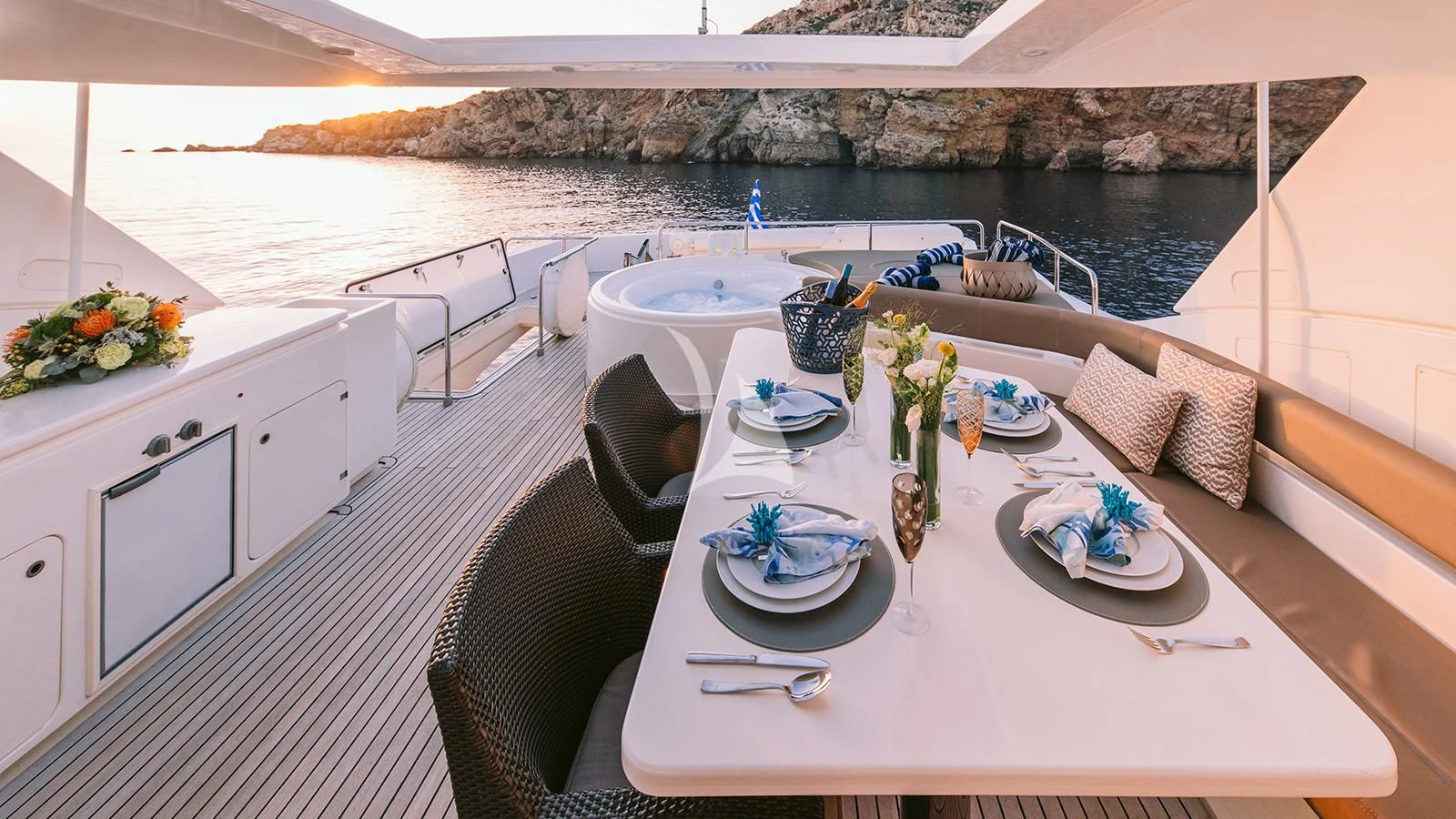 a table with plates and flowers on it aboard MELI Yacht for Charter