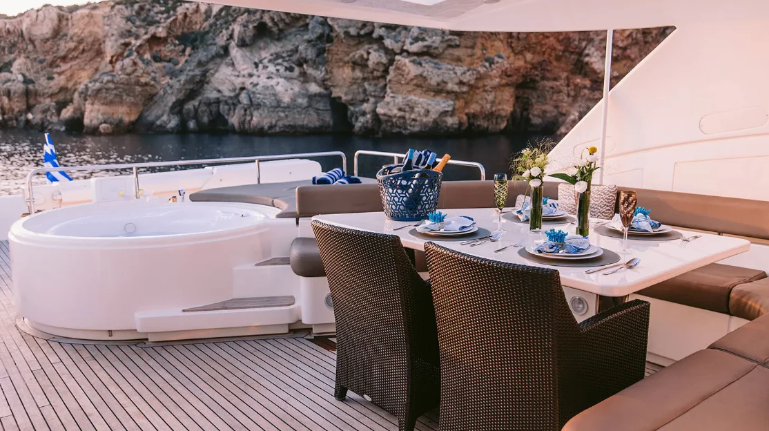 a table with chairs and a pool aboard MELI Yacht for Charter