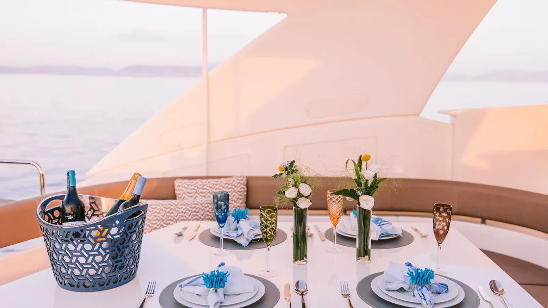 a table with plates and glasses aboard MELI Yacht for Charter
