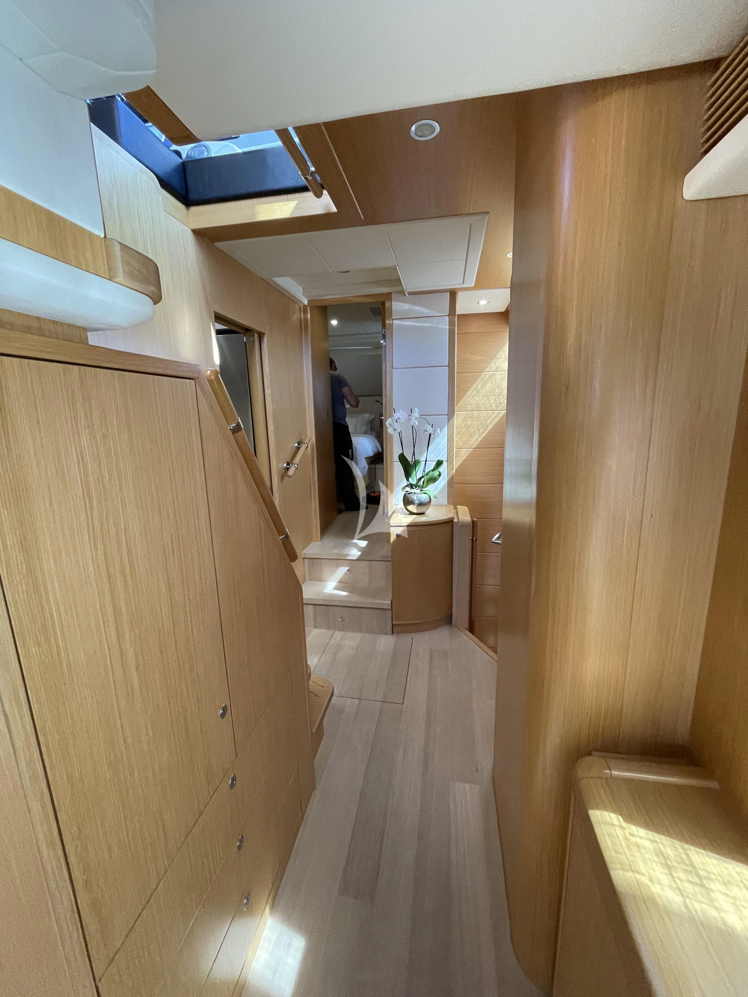 a hallway with a wood floor and a person standing in the doorway aboard MELI Yacht for Charter