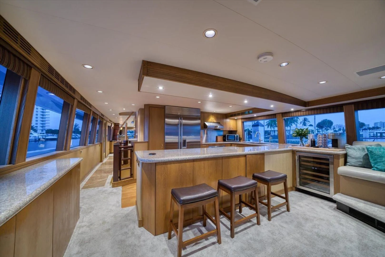 a large kitchen with a bar and bar stools aboard NORTH COAST 120 Yacht for Sale