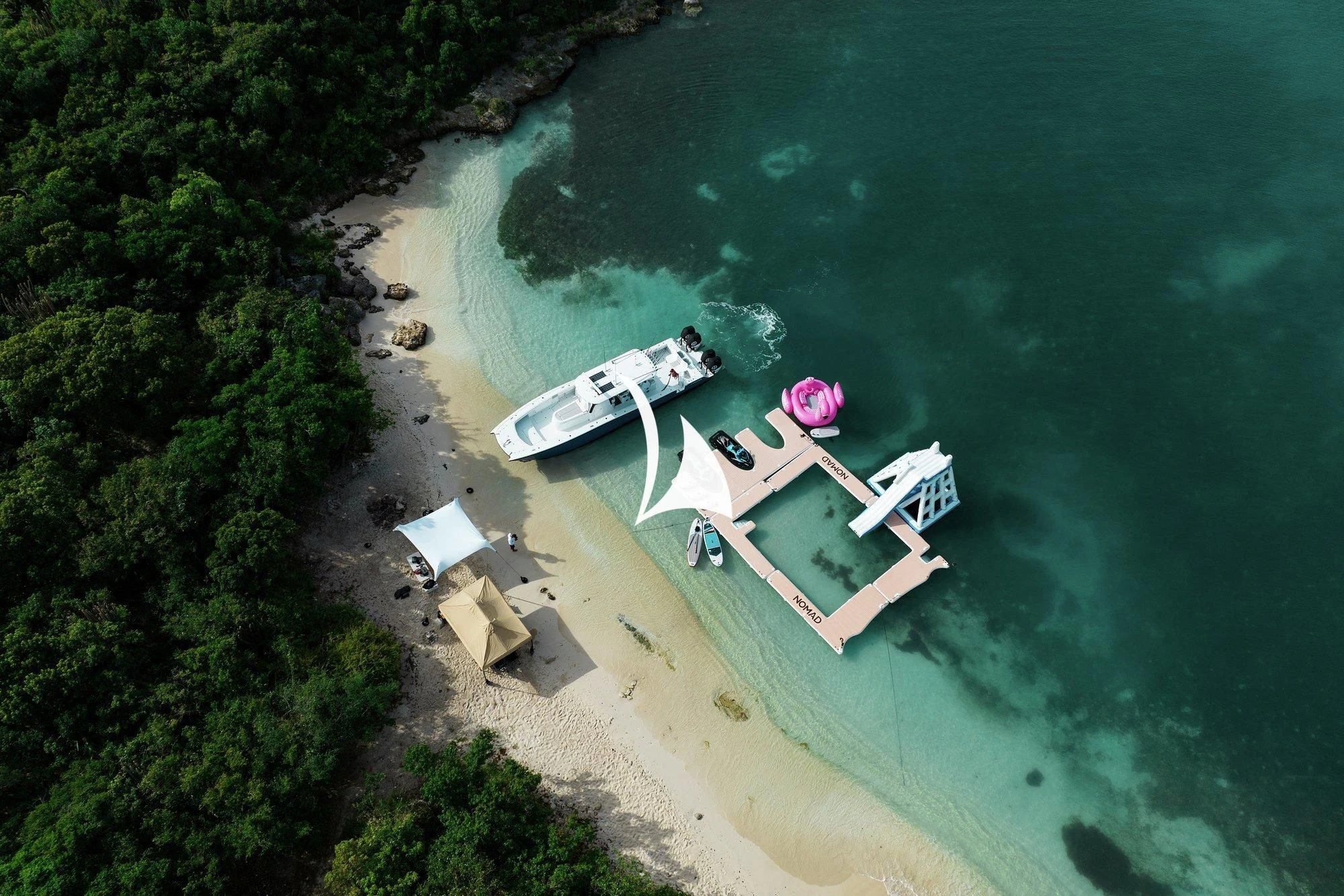 a beach with a dock and boats aboard NOMAD Yacht for Sale