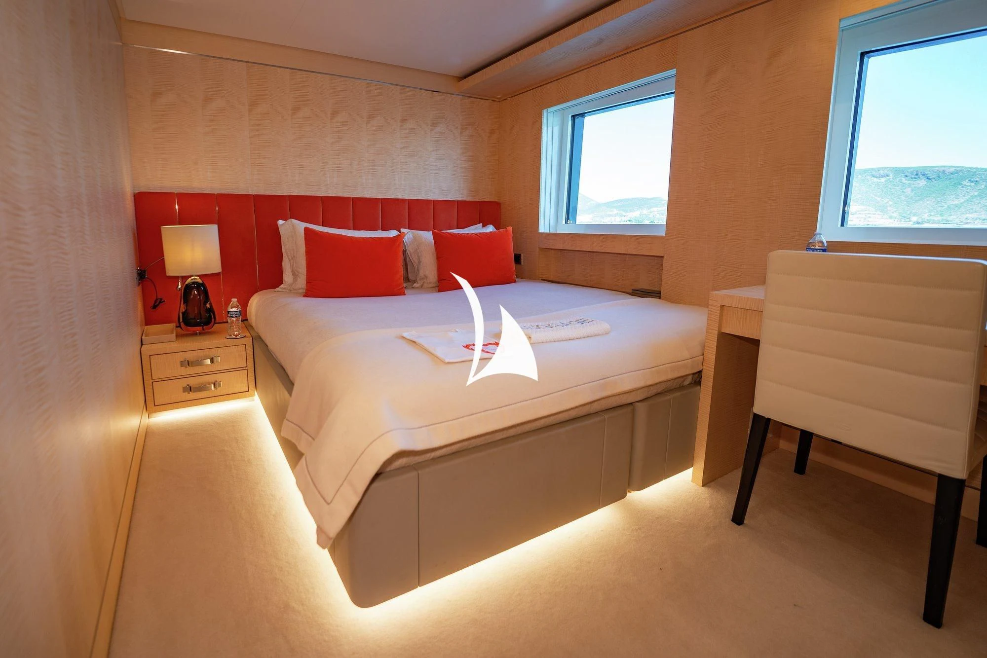 a bed with red pillows aboard NOMAD Yacht for Sale