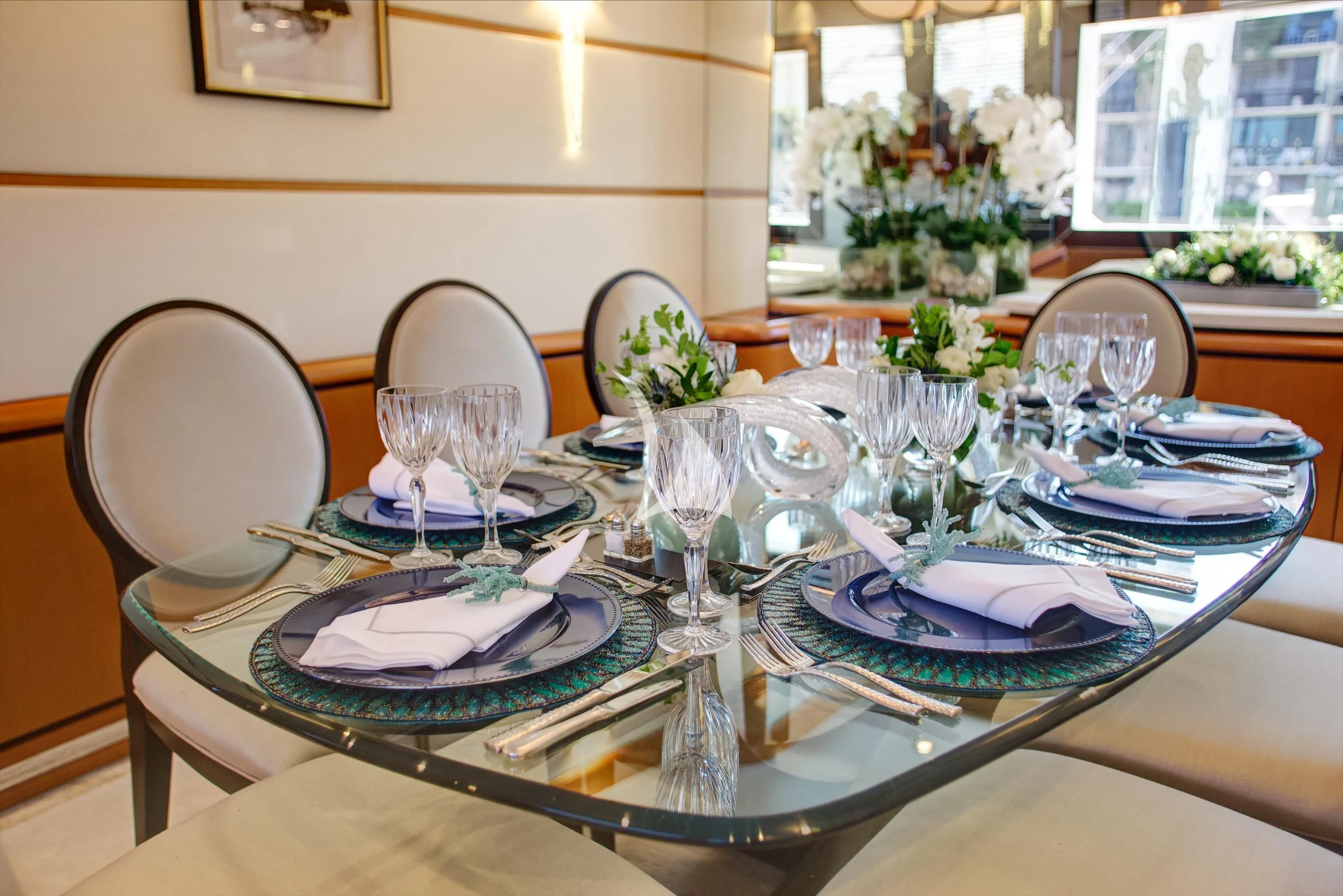 a table with plates and glasses aboard XOXO Yacht for Charter