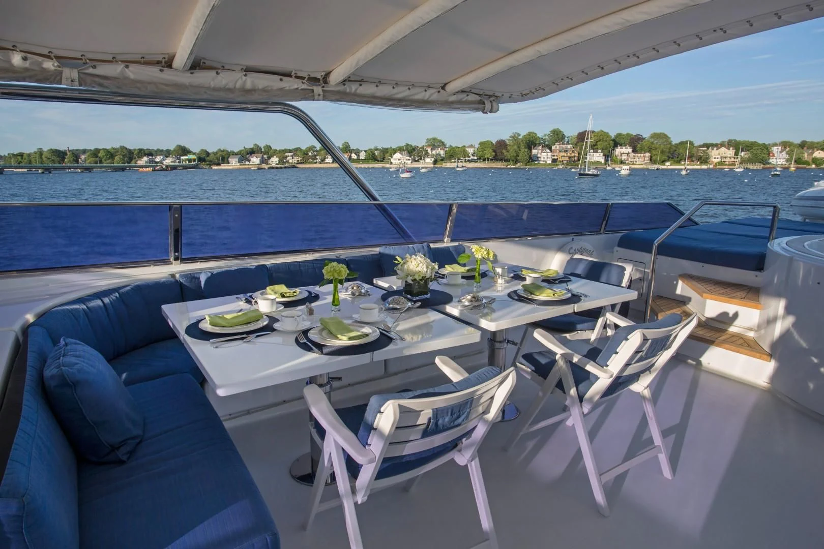 a table set for a meal on a deck overlooking a body of water aboard XOXO Yacht for Charter