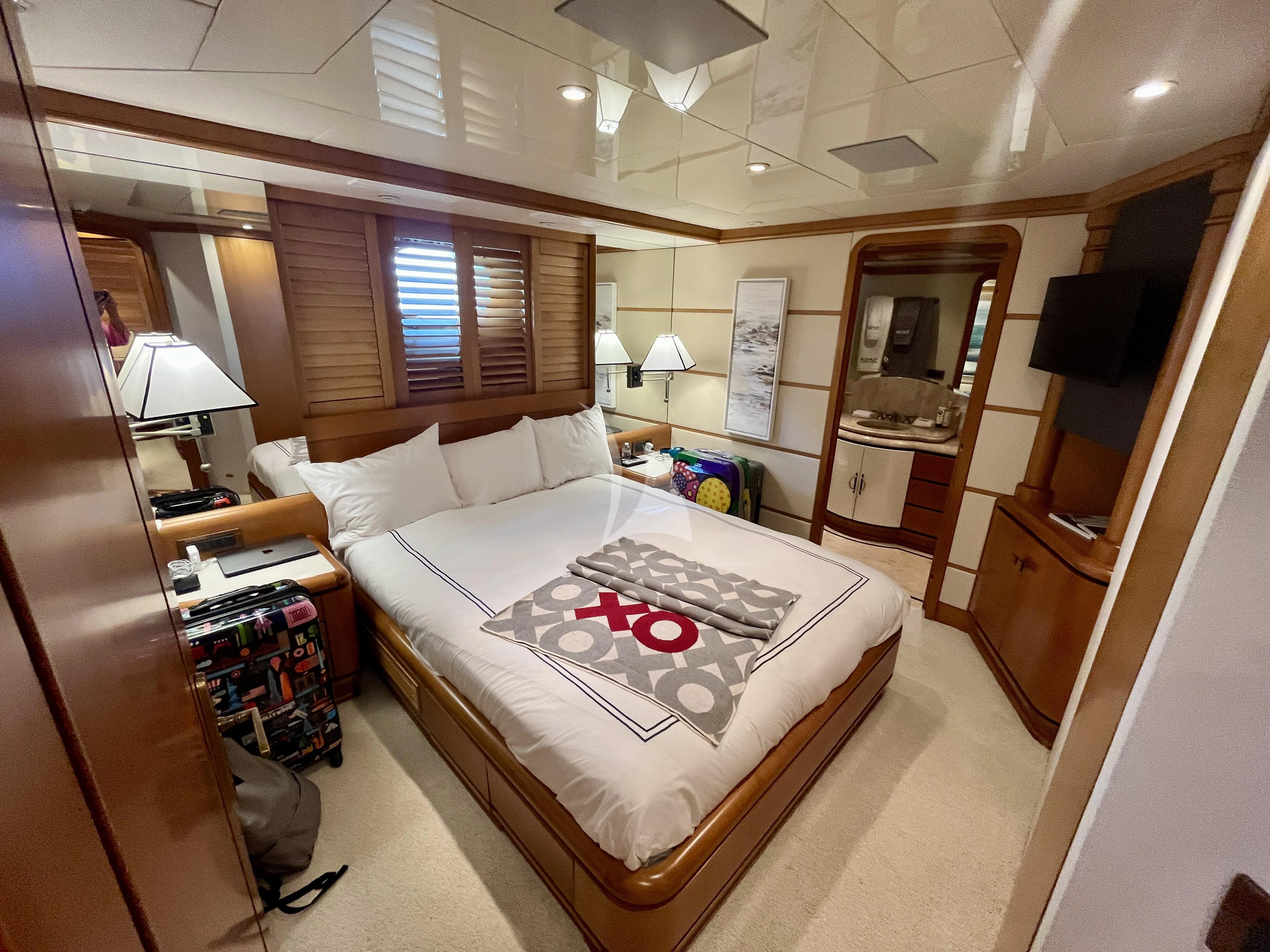 a bedroom with a bed and a desk aboard XOXO Yacht for Charter