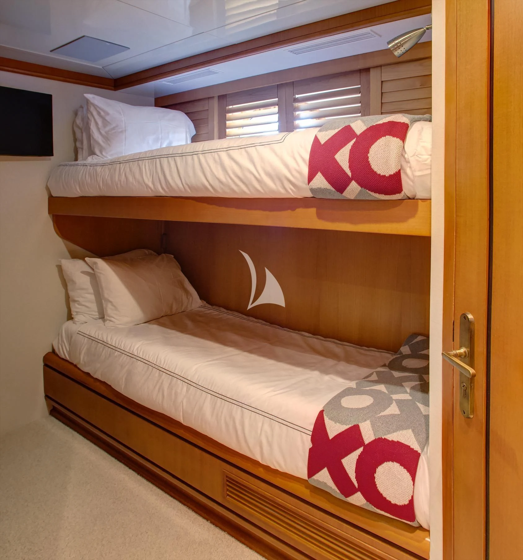 a bed with a white sheet and pink pillows aboard XOXO Yacht for Charter