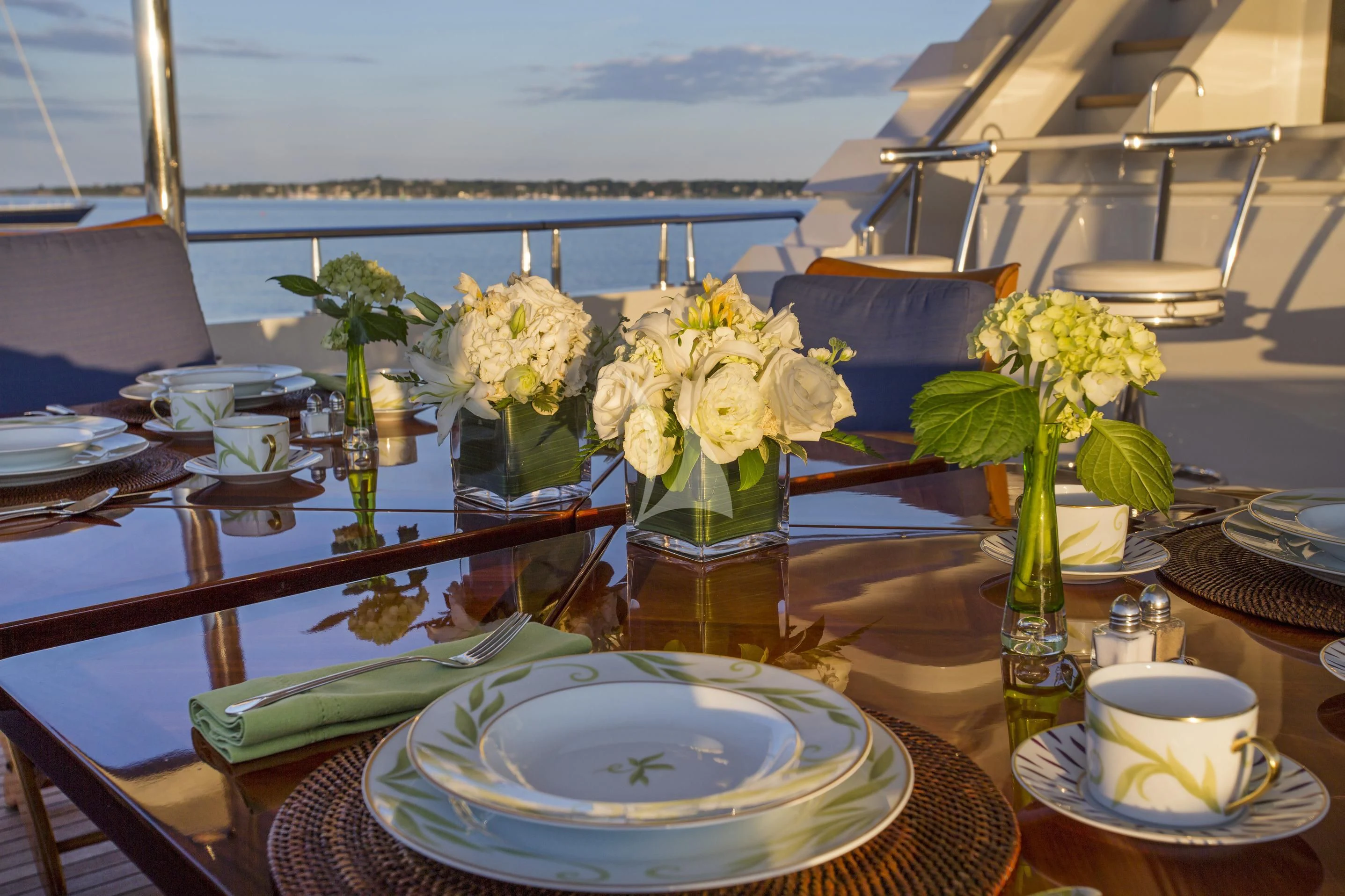 a table with a vase of flowers and a plate of food aboard XOXO Yacht for Charter