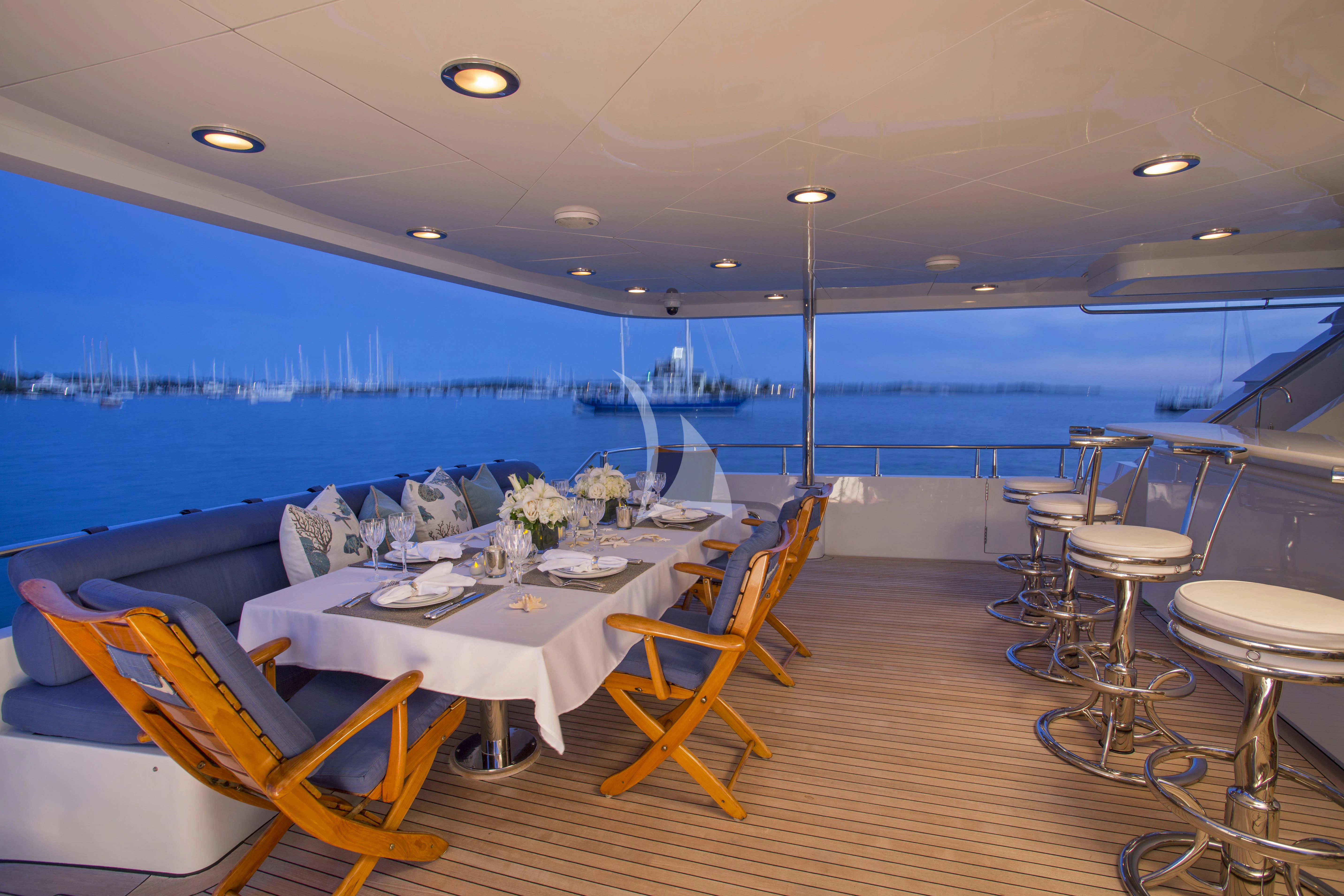 a room with tables and chairs aboard XOXO Yacht for Charter