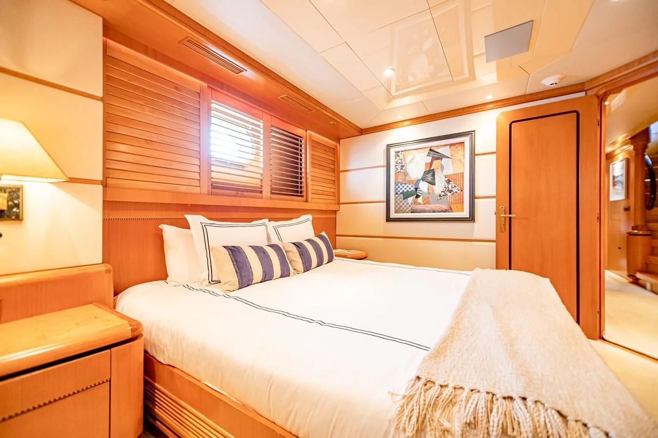 a bedroom with a bed and a window aboard XOXO Yacht for Charter