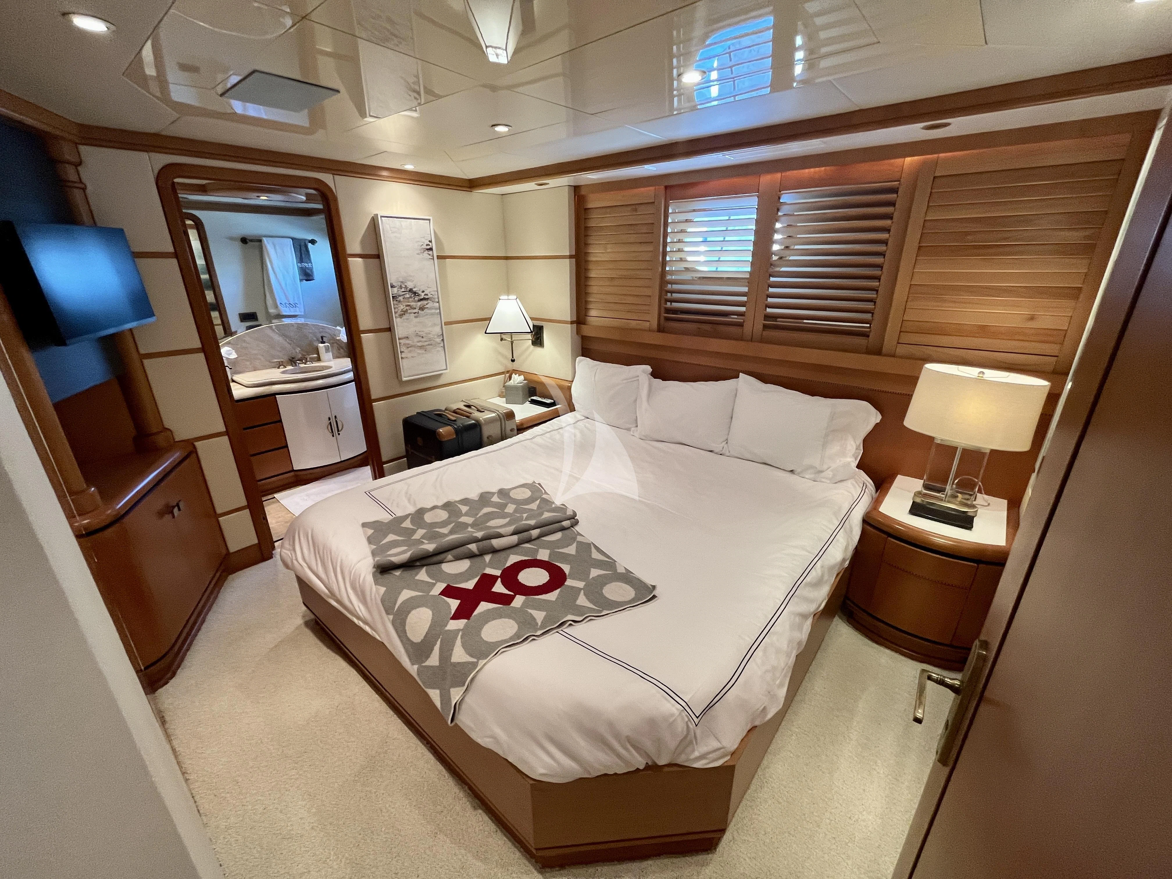 a bed with a white comforter aboard XOXO Yacht for Charter