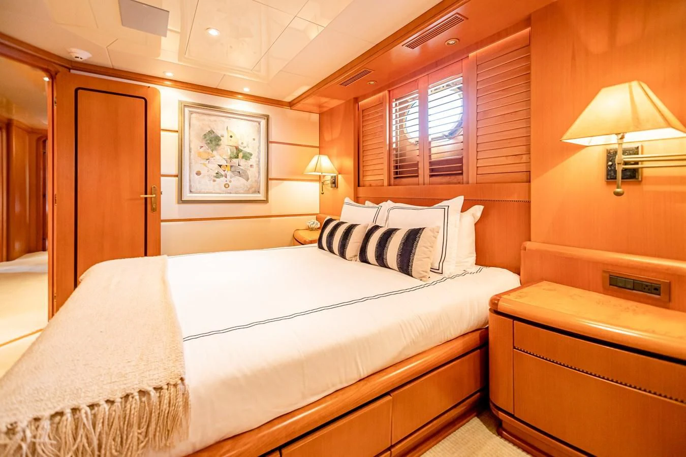 a room with a bed and a lamp aboard XOXO Yacht for Charter