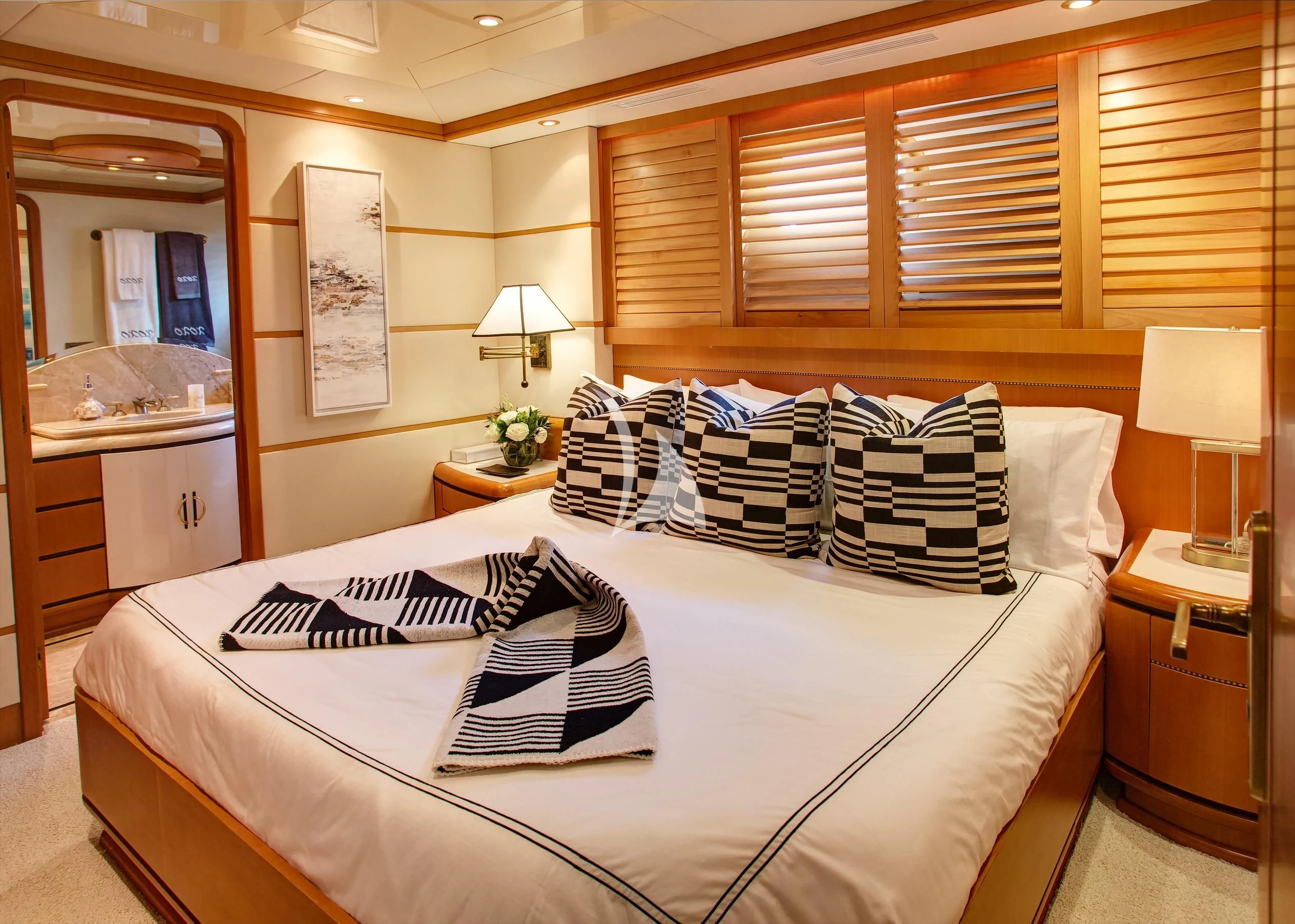 a bedroom with a bed and a mirror aboard XOXO Yacht for Charter