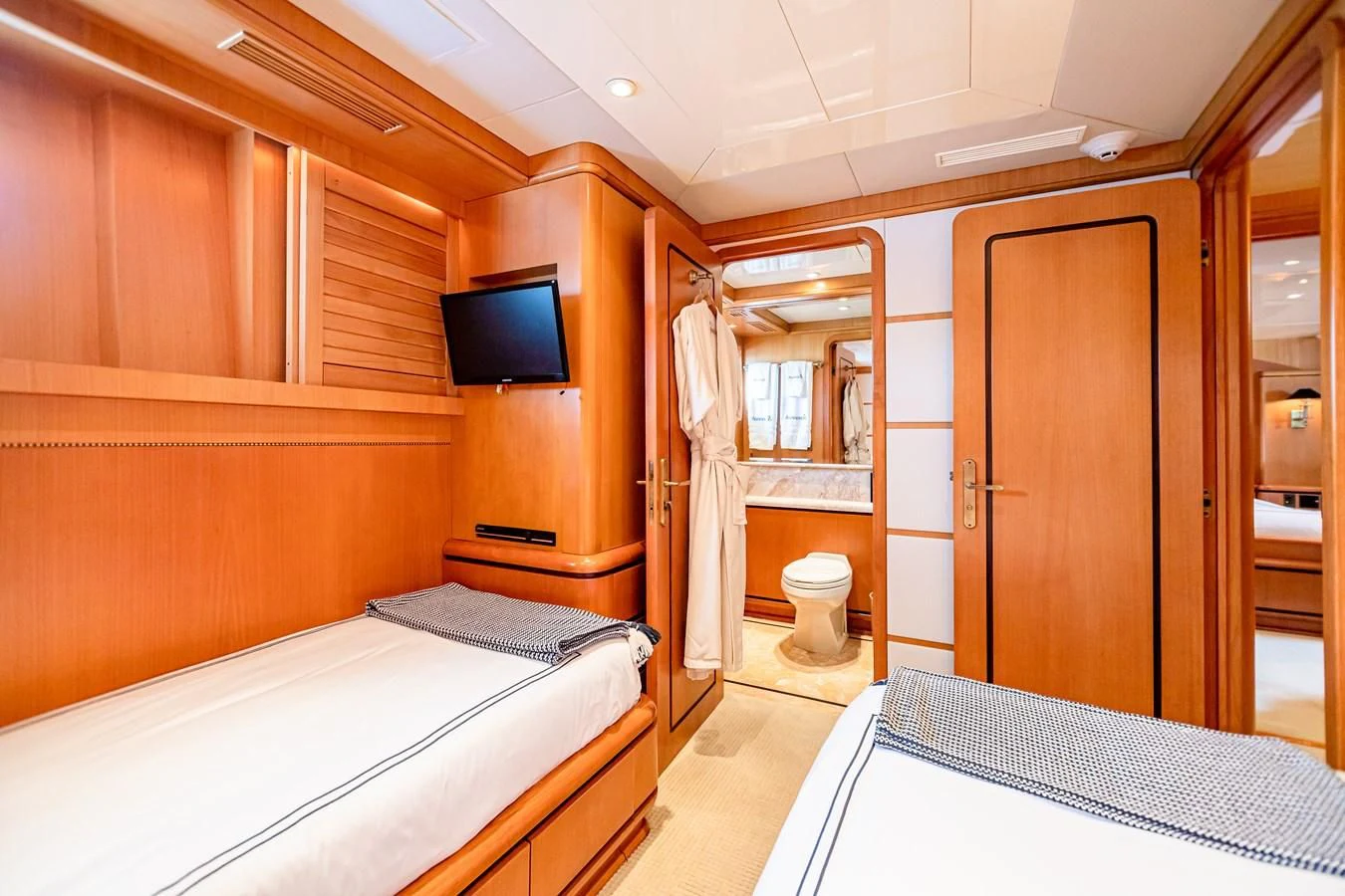 a bathroom with a bed and a television aboard XOXO Yacht for Charter