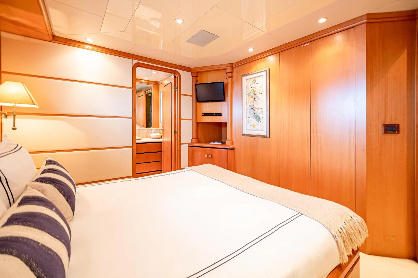 a room with a bed and a television aboard XOXO Yacht for Charter