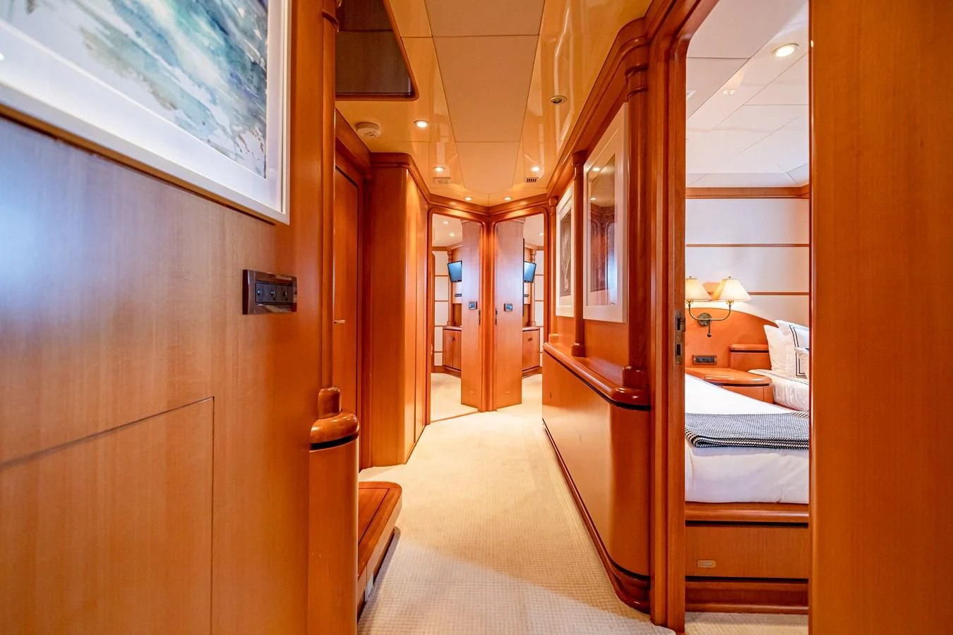 a hallway with a bed and a mirror aboard XOXO Yacht for Charter