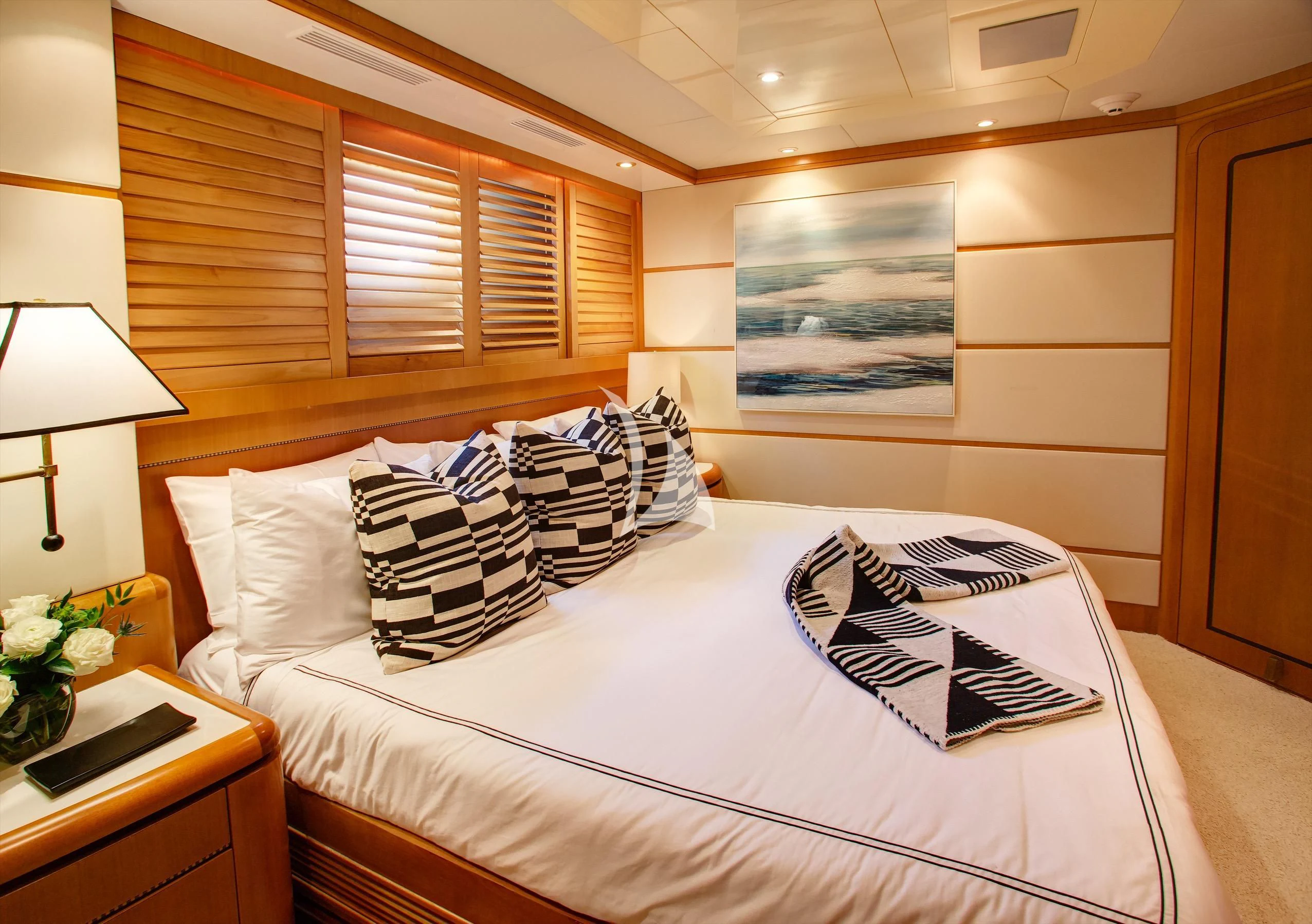 a bed with white sheets and pillows aboard XOXO Yacht for Charter