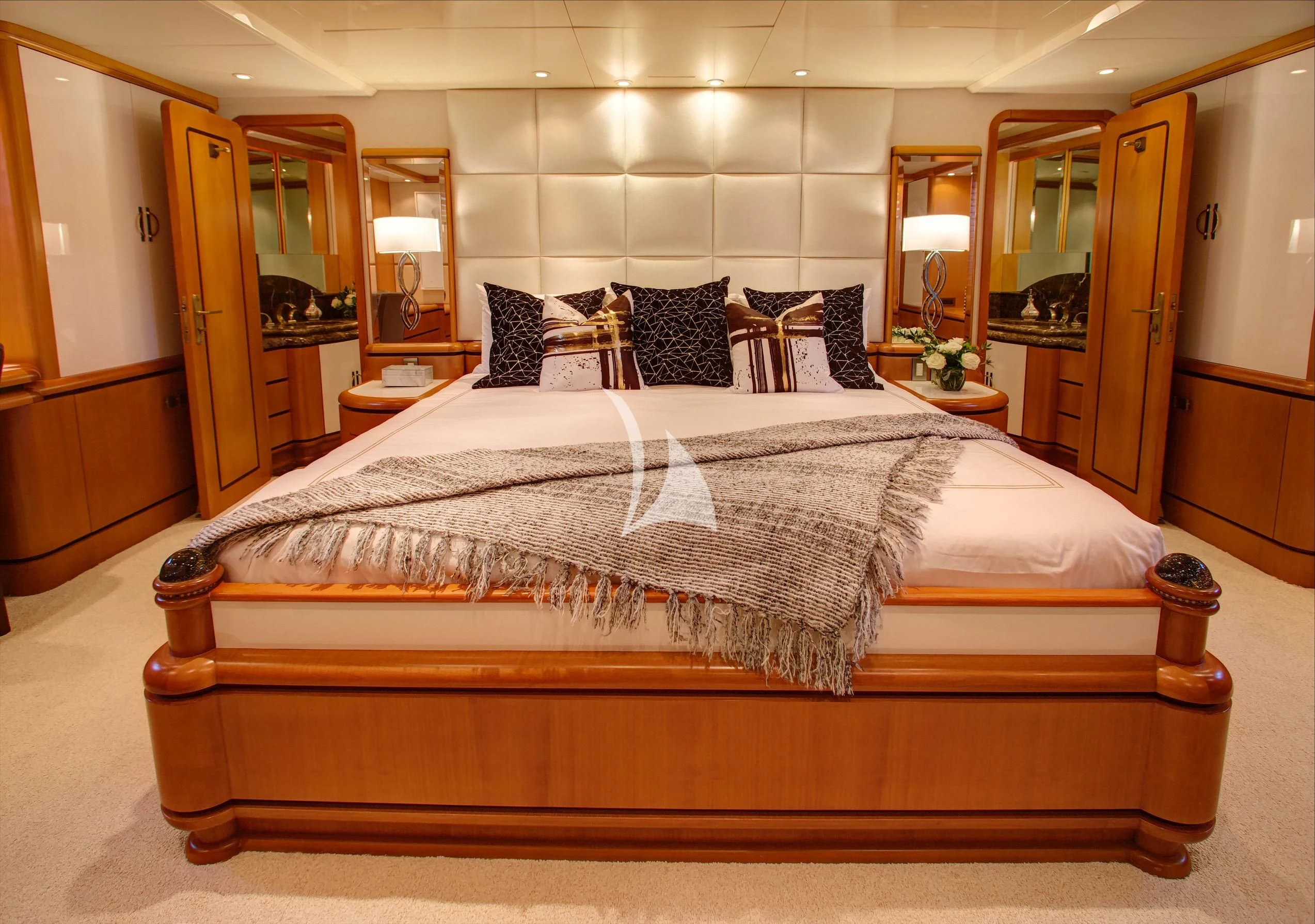 a bed with a black and white comforter and pillows aboard XOXO Yacht for Charter