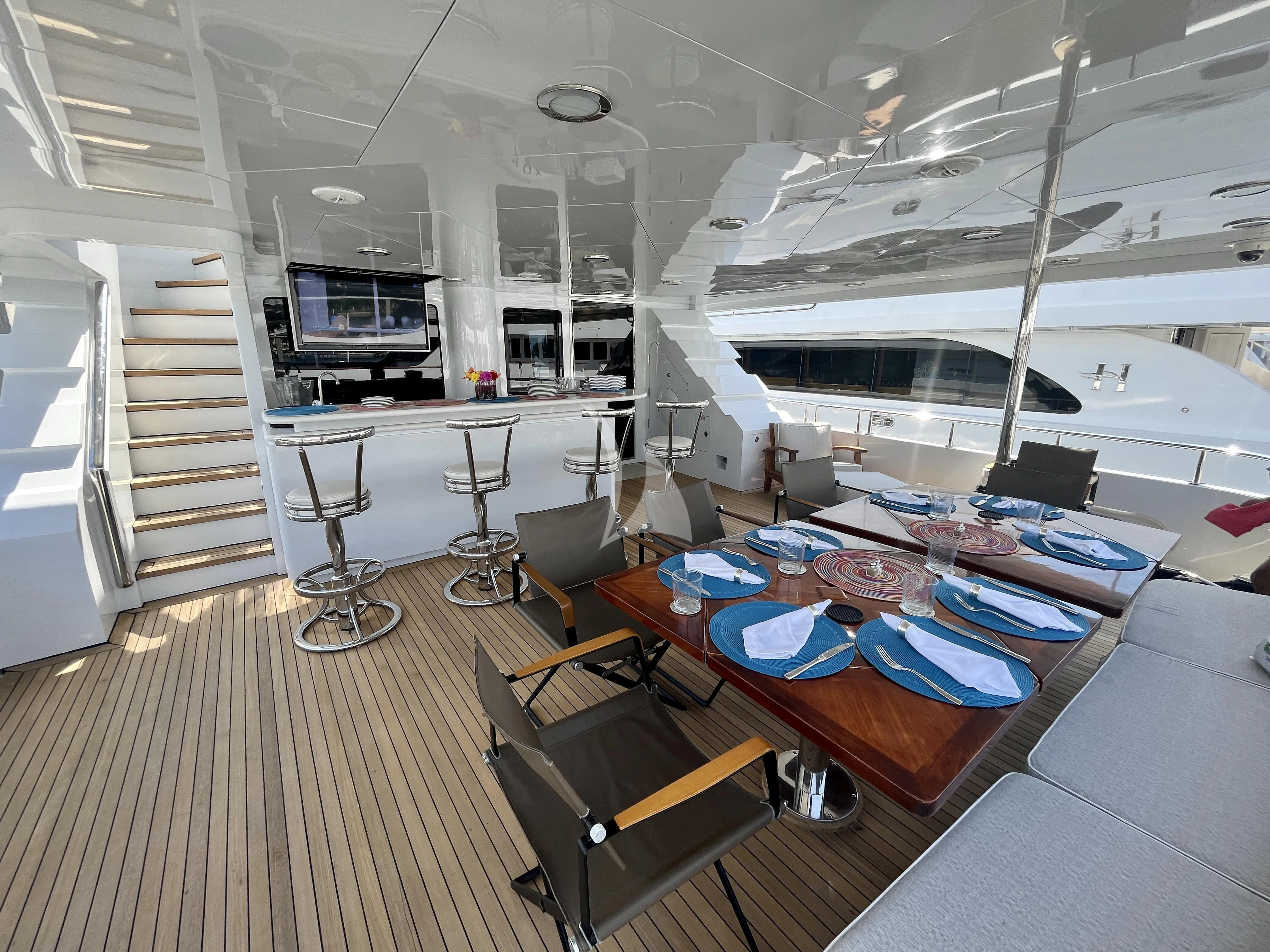 a room with a table chairs and a couch aboard XOXO Yacht for Charter