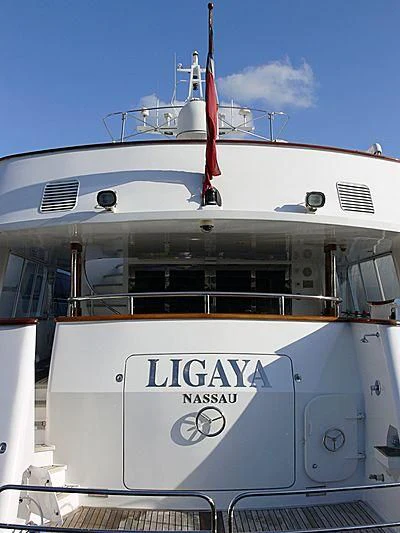 a white boat with a red flag on it aboard LIGAYA Yacht for Sale