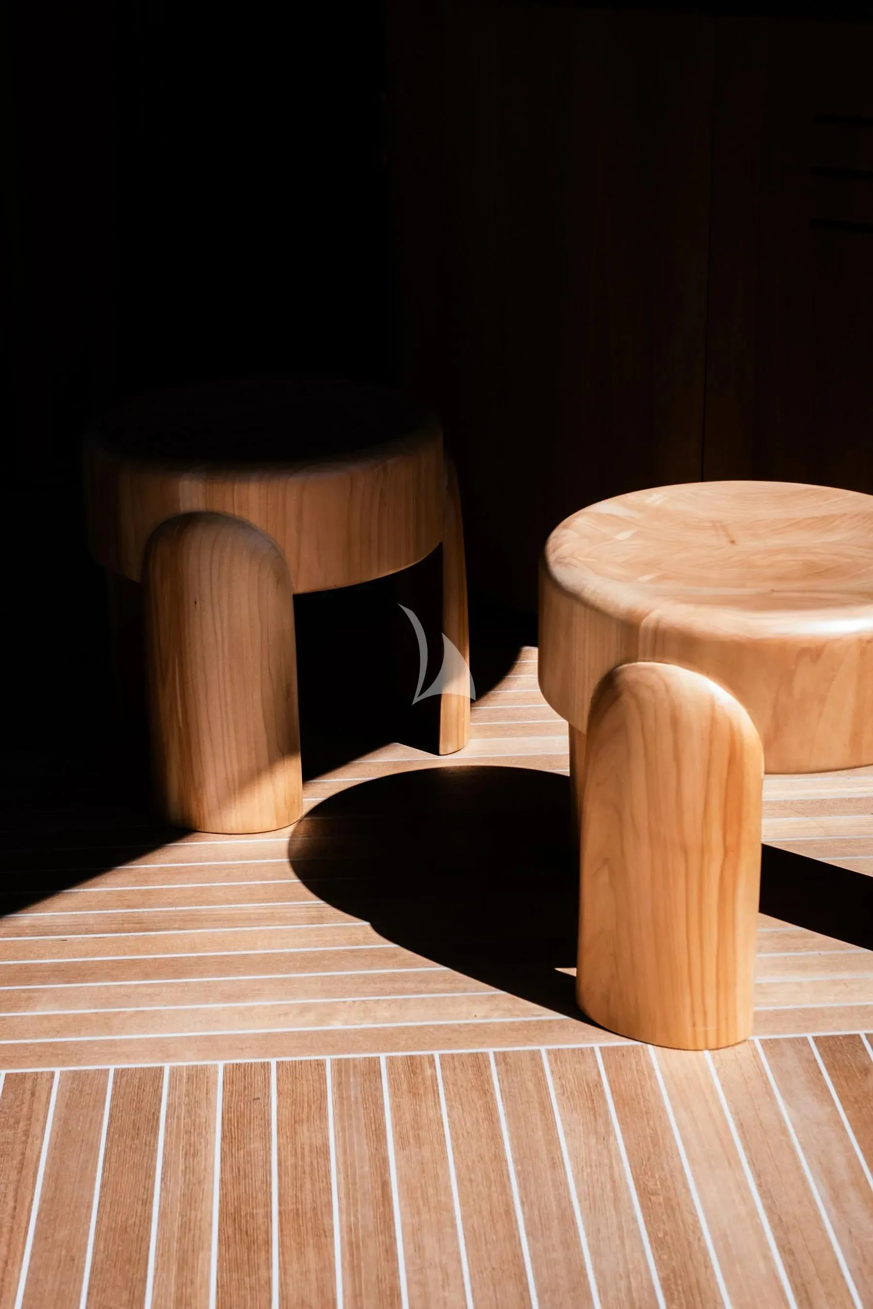 a wooden stool with a white and black striped cushion on it aboard AKIRA Yacht for Sale