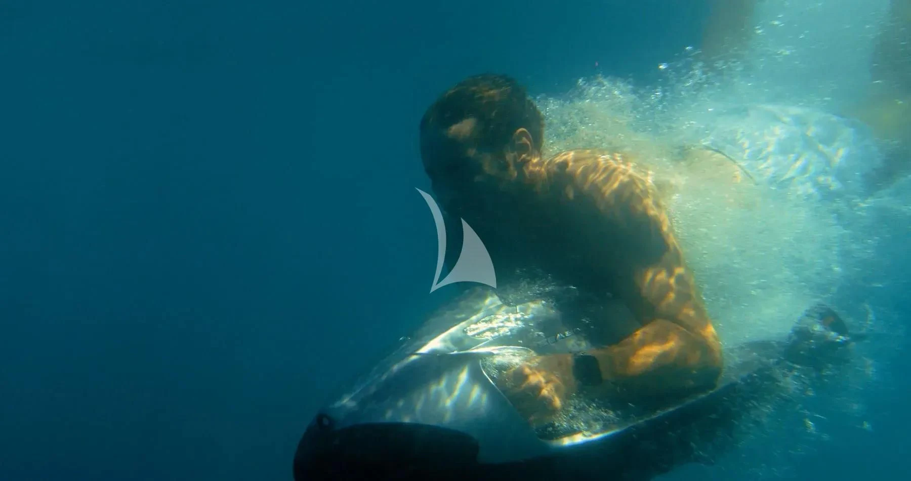 a person in a suit and tie swimming in the ocean aboard AKIRA Yacht for Sale