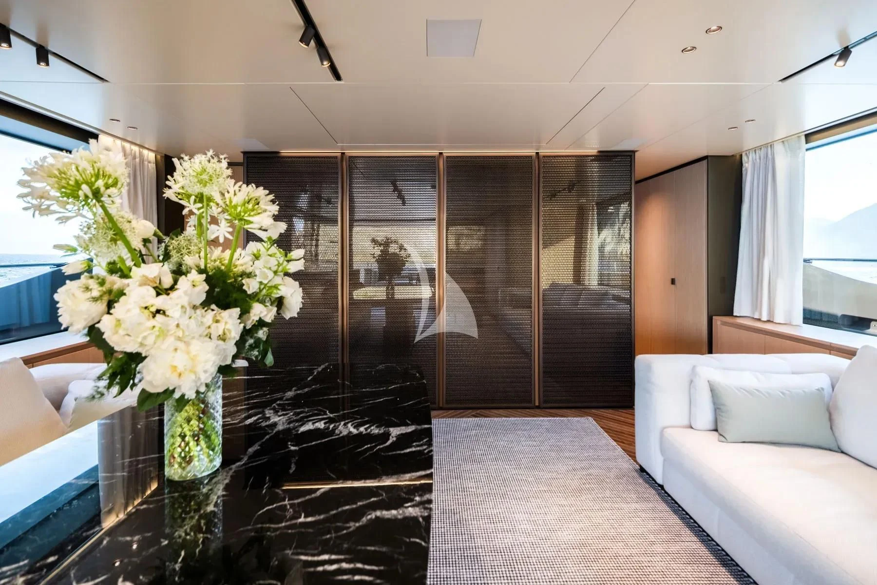 a room with a glass wall and a vase with flowers in it aboard AKIRA Yacht for Sale