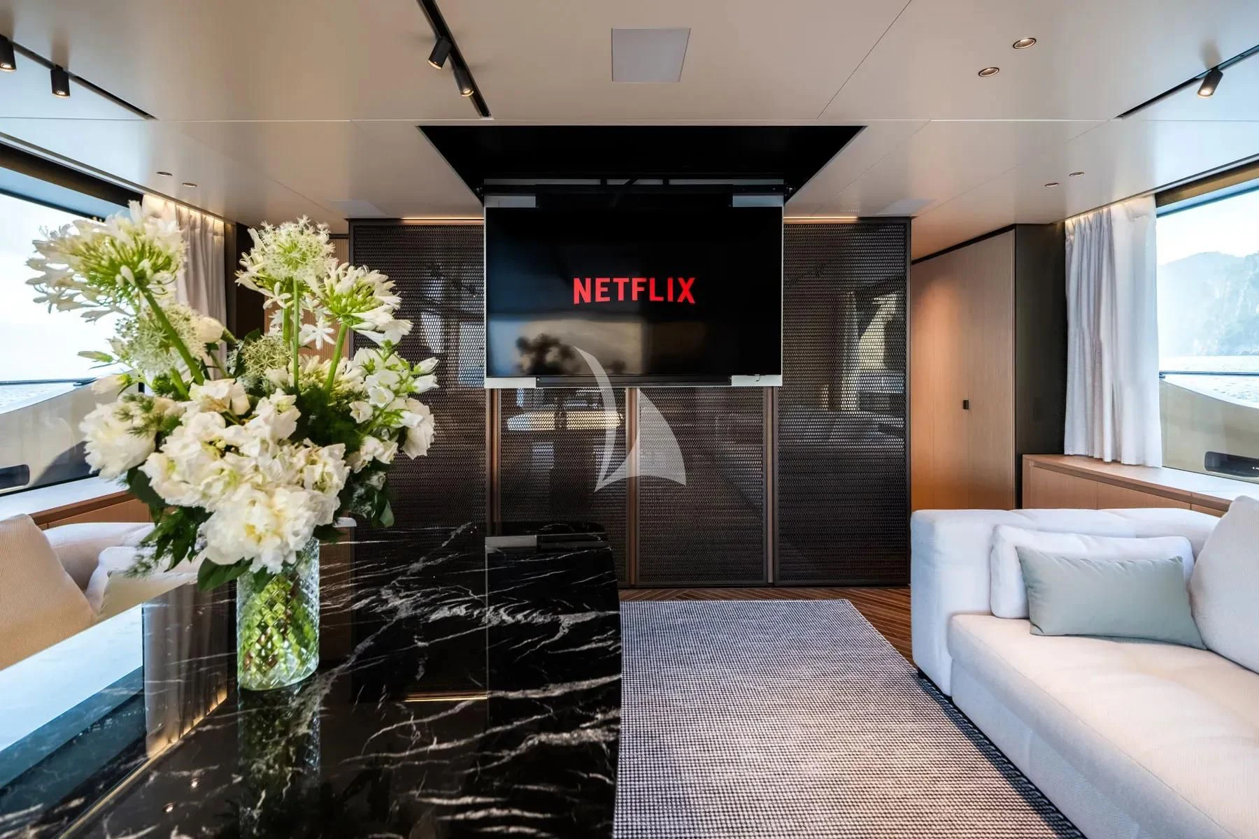 a lobby with a glass wall and a tv on the wall aboard AKIRA Yacht for Sale