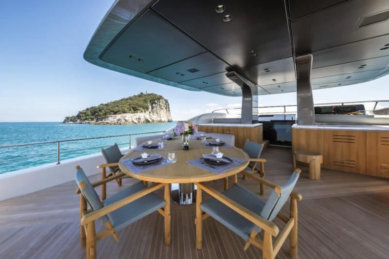 a table and chairs on a deck aboard AKIRA Yacht for Sale