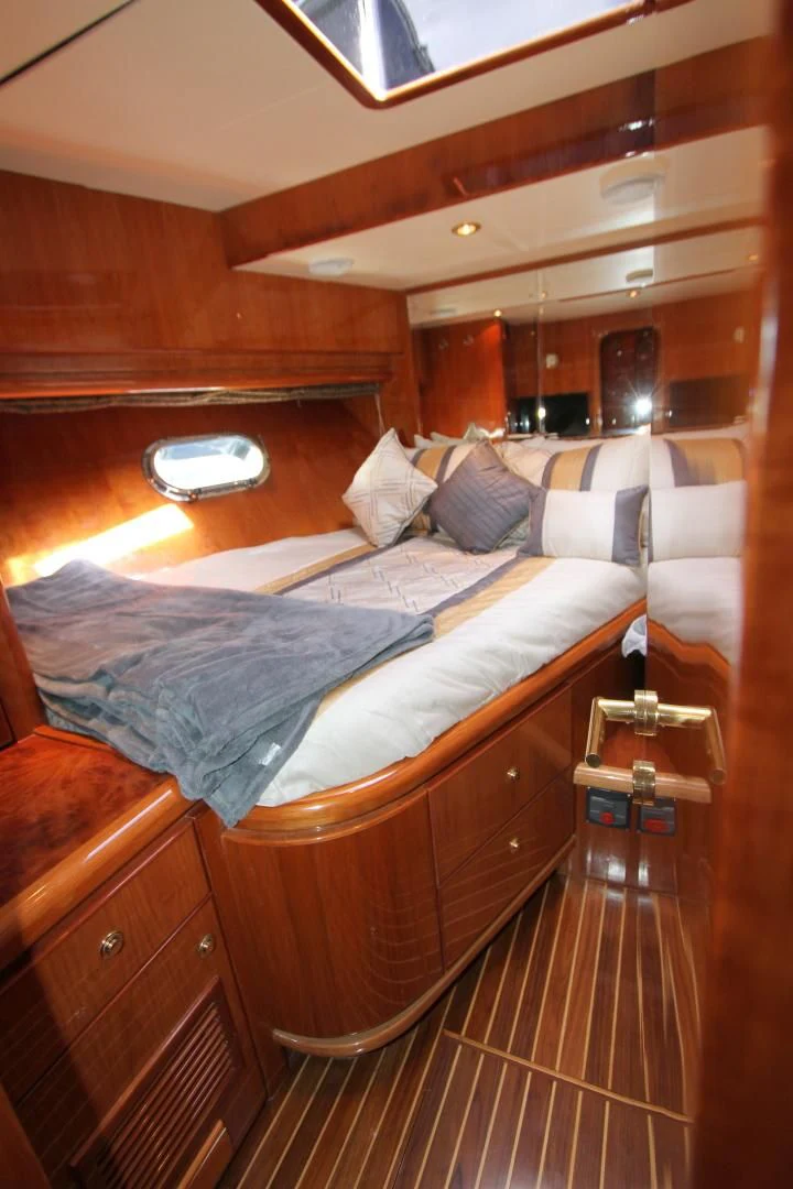 a bed with a wooden headboard aboard KISMET Yacht for Sale