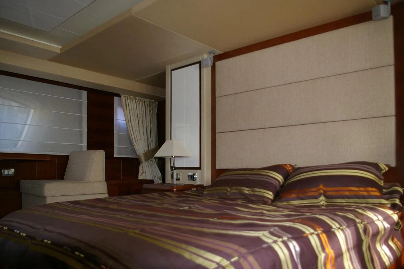 a bedroom with a bed and a chair aboard VICTORIA V Yacht for Sale