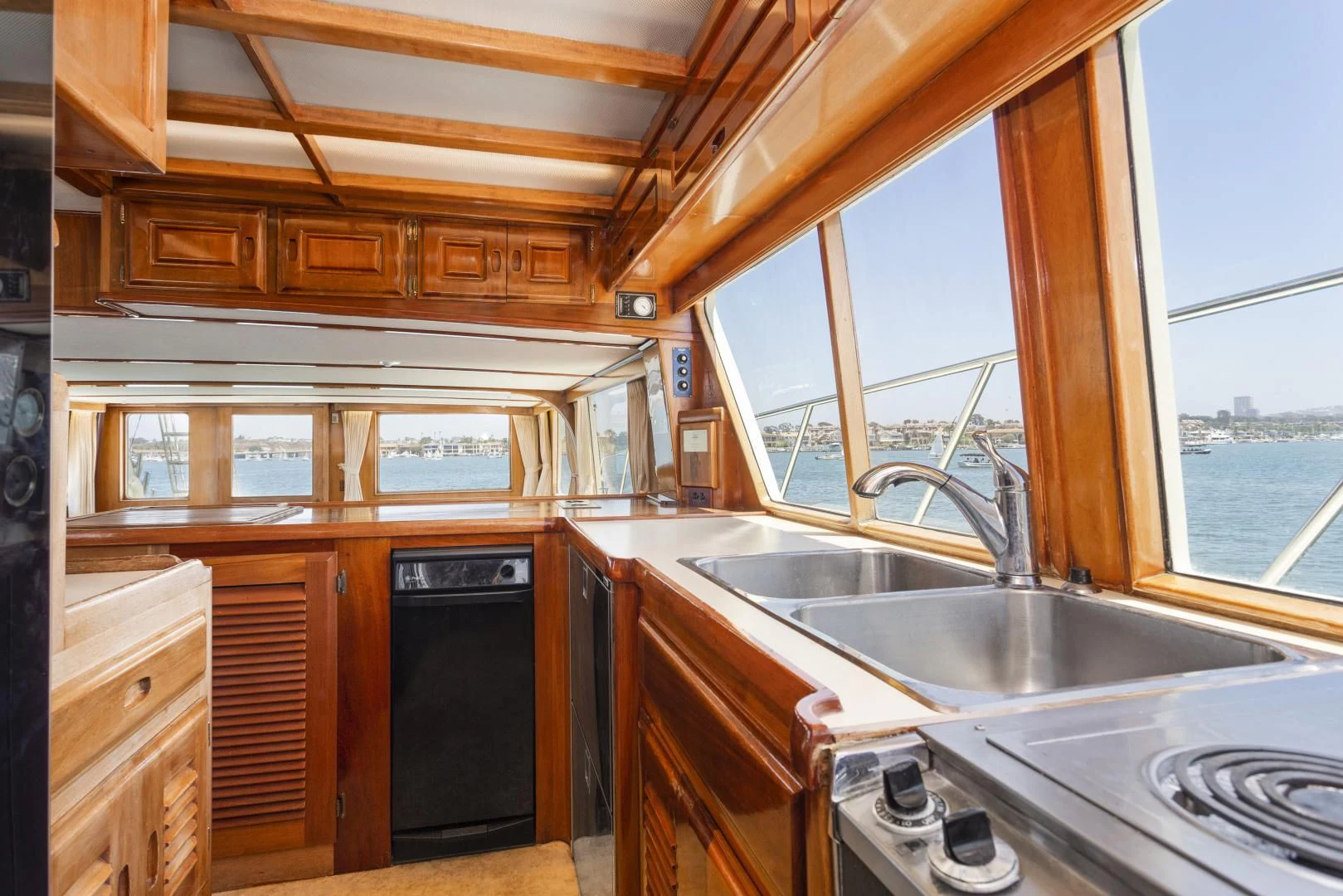 a kitchen with wooden cabinets aboard EL AMO Yacht for Sale
