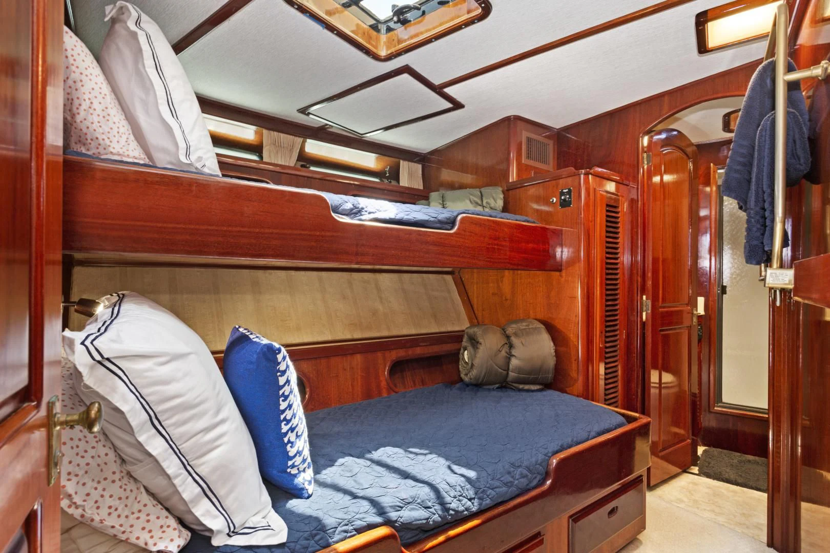 a bed with blue pillows aboard EL AMO Yacht for Sale