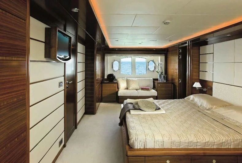 a bedroom with a bed and a tv on the wall aboard BAMBINA Yacht for Sale