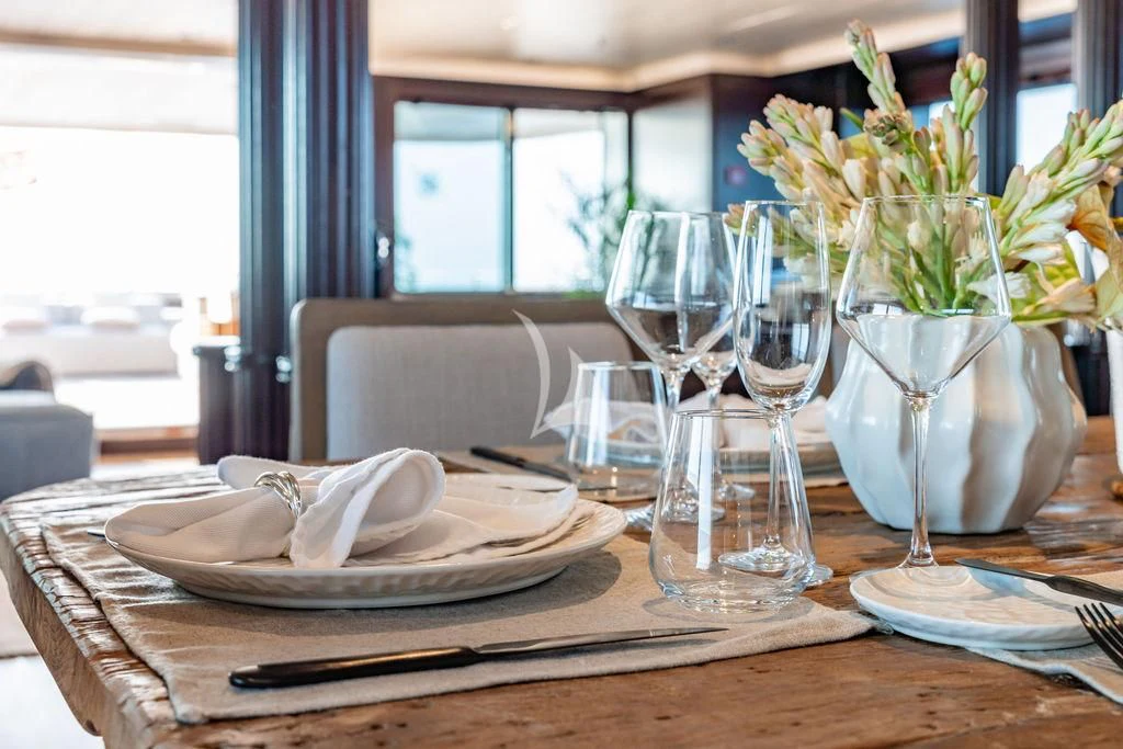 a table with plates and glasses aboard GALILEO Yacht for Sale