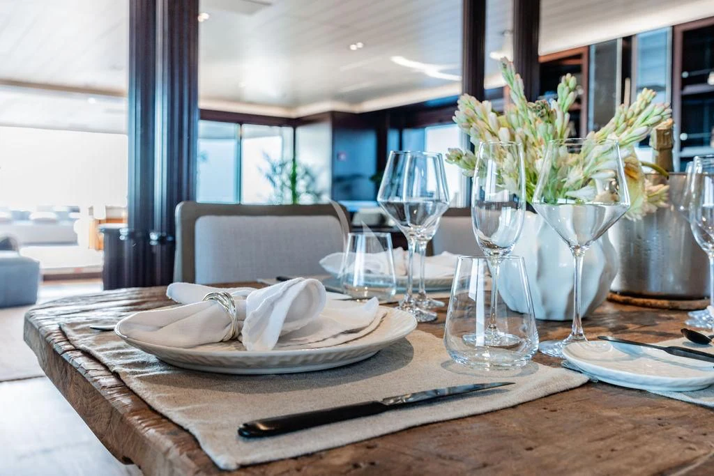 a table with plates and glasses aboard GALILEO Yacht for Sale