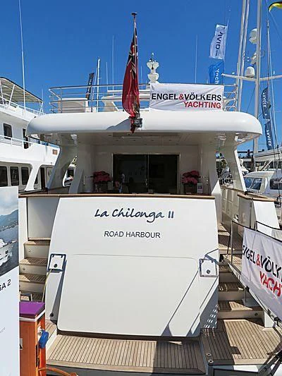 a large white boat with a flag on the front aboard KALISA Yacht for Sale