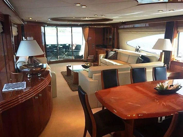 a room with a table chairs and a couch aboard NATALIA Yacht for Sale