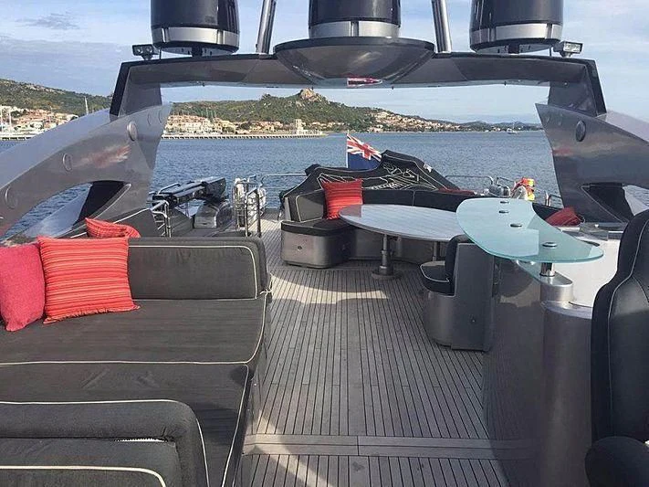 a deck with a boat and a deck with chairs and a table with chairs on it aboard NATALIA Yacht for Sale