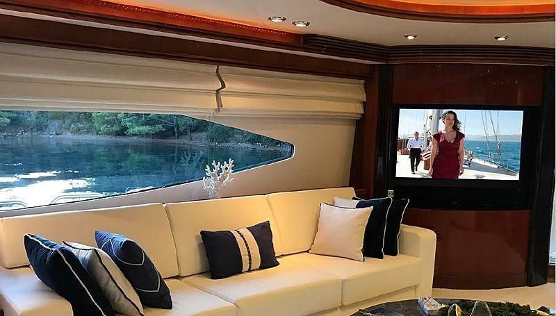 a room with a couch and a television aboard NATALIA Yacht for Sale