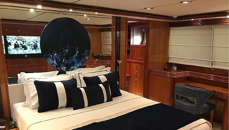 a bed with a large black headboard and a large black ball on the top aboard NATALIA Yacht for Sale