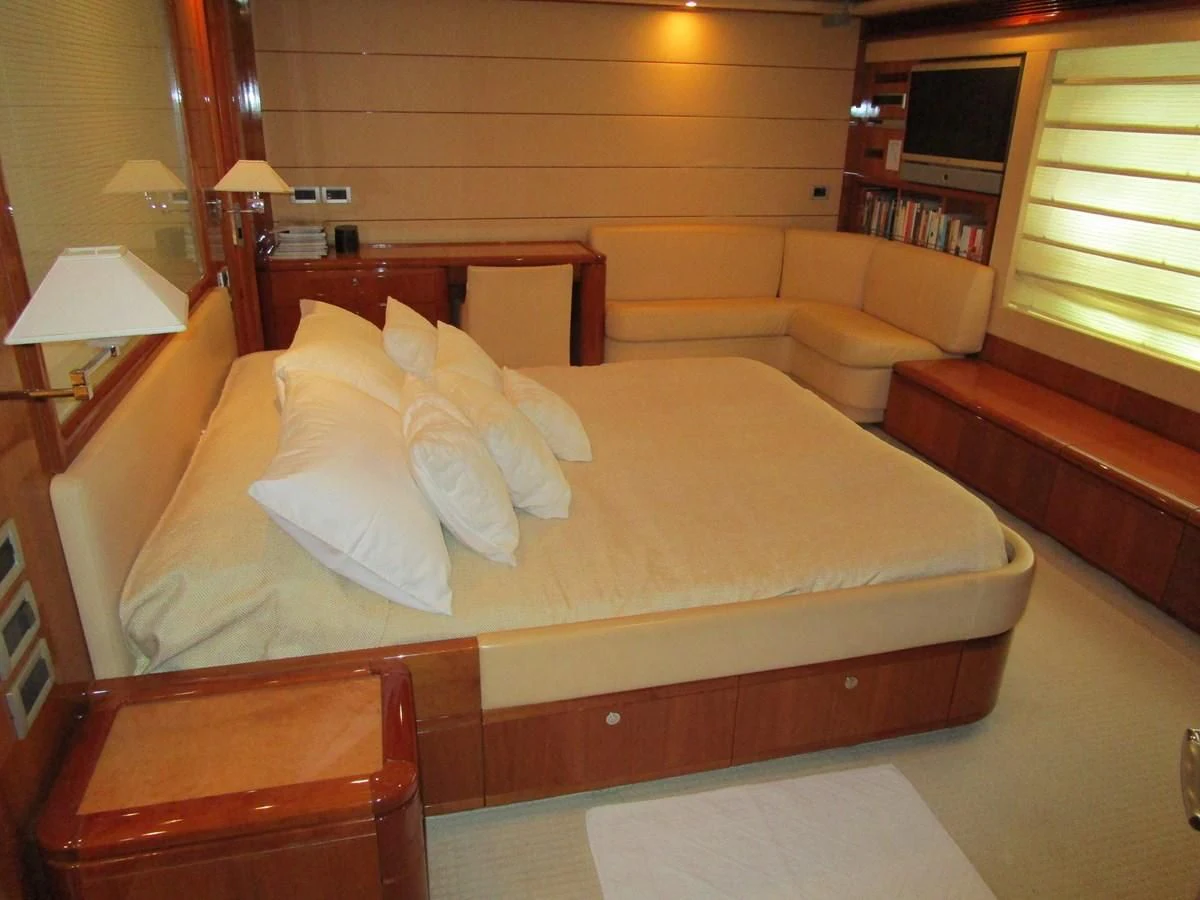 a bed with a brown comforter aboard NACL Yacht for Sale