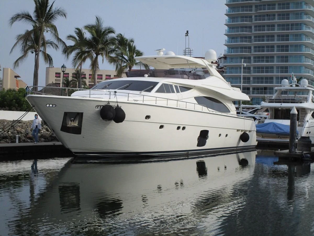 a white yacht docked at a pier aboard NACL Yacht for Sale